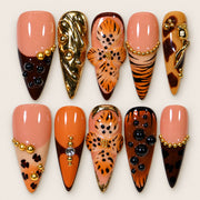 ACEGRIP Blush Spotted Zebra press-on nails in peach nude, black, orange, and gold tones, with leopard-like spots, style HM5038