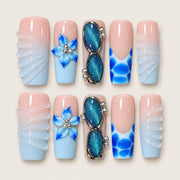 ACEGRIP Blush Blossom Shells press-on nails in peach nude, blue, white, and silver tones, with floral accents, style XQ2032